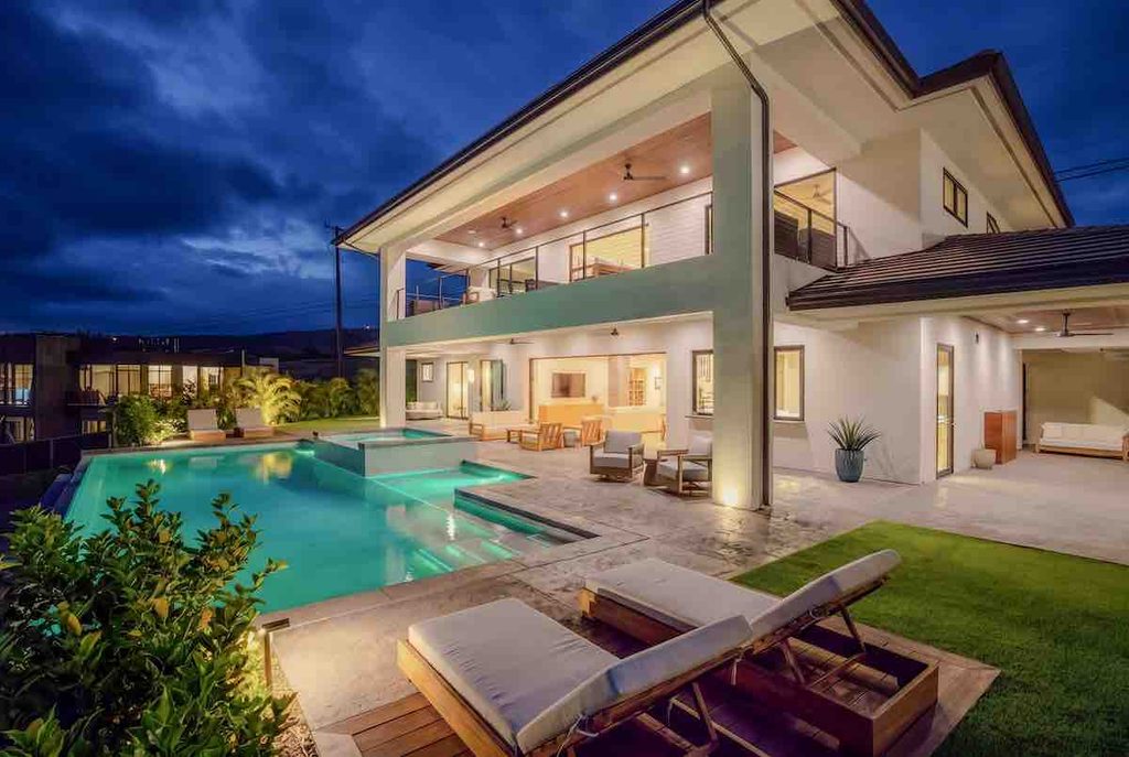 August 2026 Maui Statistics and Market Update 1 Evening and 22 Halapa Place in Wailea Ridge. The two story luxuty home and its pool area are fully illuminated. A couple of pool side lounge chairs are in the foreground.